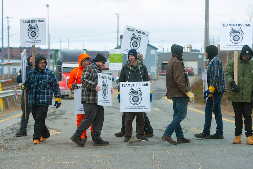 Striking CN rail workers walk the picket line in front of the CN Intermodal Rail Terminal on Africville Road Nov. 21 in Halifax, N.S.