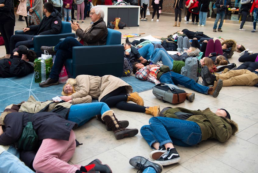 Protesters take part in a die-in as part of a climate strike rally against Black Friday and overconsumption inside the Halifax Shopping Centre on Friday, Nov, 29, 2019.