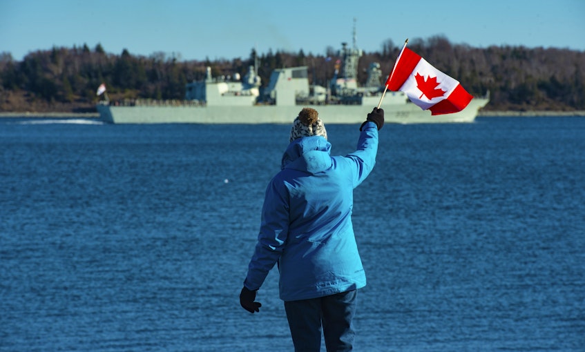 Mary MacAfee waves a Canadian flag as she watches HMCS Halifax leave on a six-month deployment as part of NATO's Operation Reassurance on Friday, Jan. 1, 2021. - Ryan Taplin