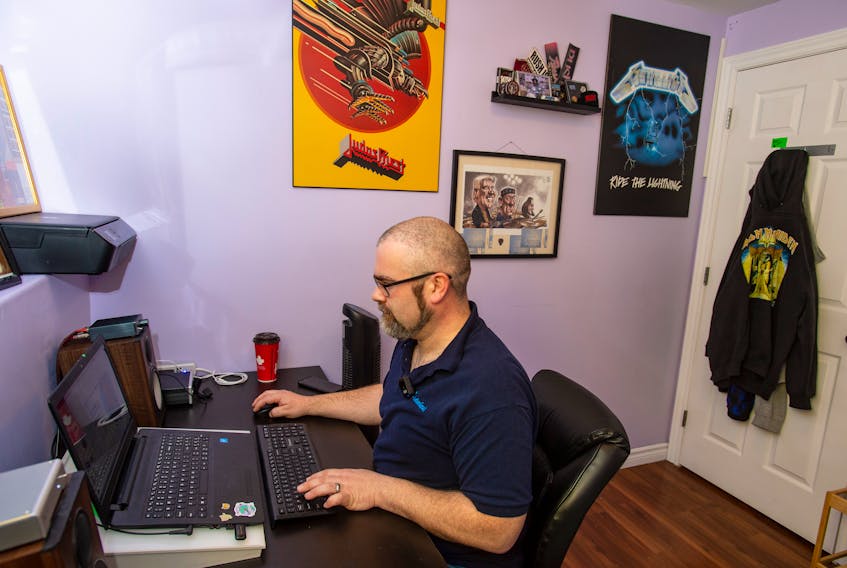 With his heavy metal poster on the wall next to him, Kyle Davis, communications coordinator with Admiral Insurance, works from his home office in Eastern Passage on Friday, January 8, 2021.