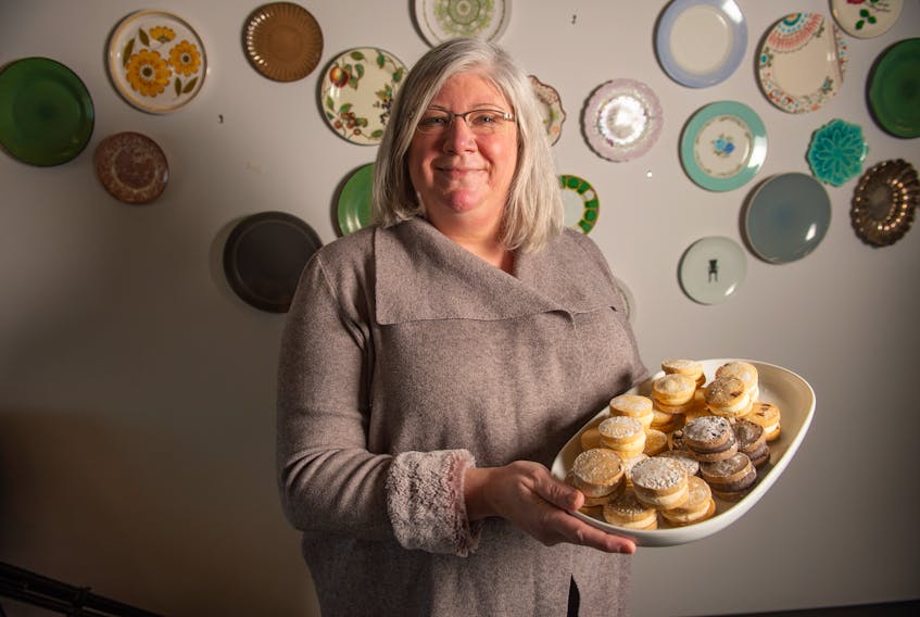 Patty Howard, owner of Kitchen Door Catering, holds a tray full of Yo-Yo cookies at her Dartmouth facility on Wednesday, Jan. 13, 2021.