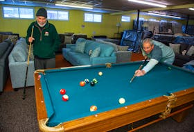 Abe Younis (left) and his son Yama play on the pool table inside the Abe's Furniture showroom in Mahone Bay on Friday, Jan. 25, 2021. Yama took over the business from Abe decades ago, but Abe can often be spotted hanging around the store.
