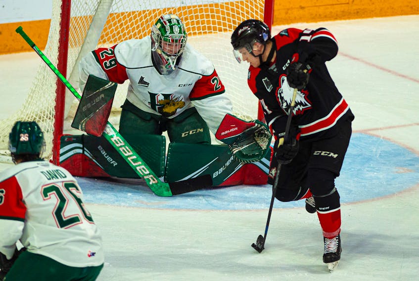 Rouyn-Noranda Huskies forward Mathieu Gagnon tries to corral a rolling puck in front of Halifax Mooseheads goalie Cole McLaren during Saturday night's QMJHL game at the Scotiabank Centre. The Huskies topped the Moose 4-1. (Ryan Taplin/The Chronicle Herald)