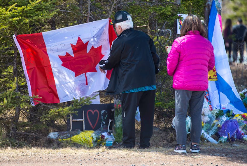 Garry Rogers and his wife Stella place a Canadian flag at a memorial at the end of Portapique Beach Road on Wednesday, April 22, 2020. Rogers lives in Truro but is originally from Cape Breton. He wanted to place the flag on behalf of the people of Cape Breton who can’t come in person to express their condolences.