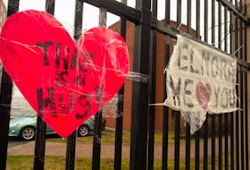 Homemade signs of support and affection are taped to a metal fence across from the Northwood Manor on Gottingen Street in north-end Halifax.