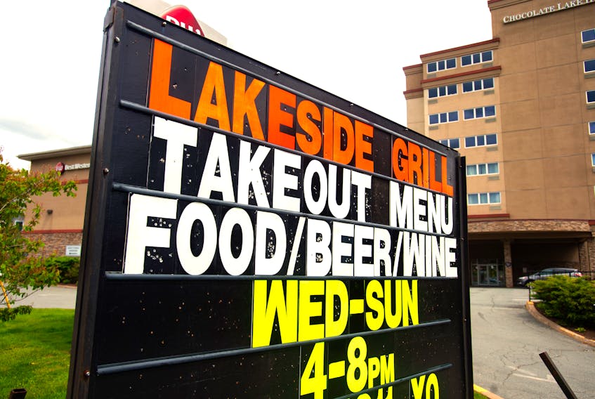 A sign outside the Lakeside Grill in the Chocolate Lake Hotel highlights the option of ordering beer and wine with your food takeout order.