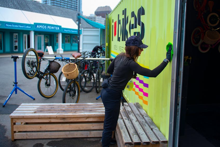 Sarah Craig, owner of I Heart Bikes, cleans the walls at her Halifax shop on Thursday, June 25, 2020. This is the 10th season for the waterfront business.