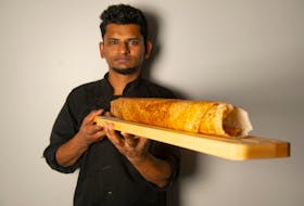 Chef Dinu Mathew holds a ghee roast dosa at Spice Hub Indian Kitchen on Wednesday, November 18, 2020. Mathew is one of the partners in the new Westphal restaurant.