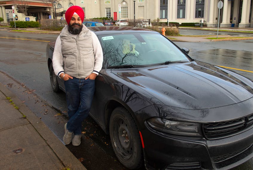 Uber driver Gurmeet Randhawa poses for a photo next to his car on Hollis St. on Sunday, December 6, 2020.