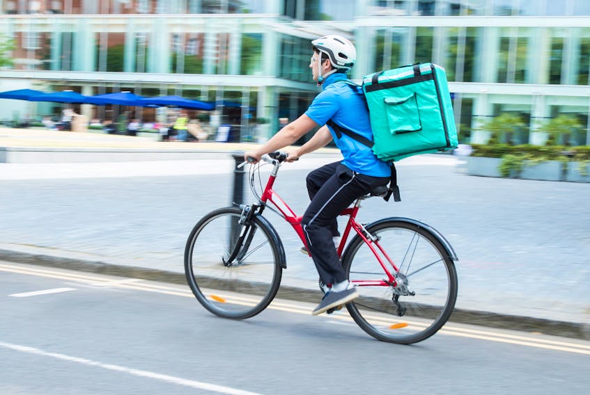 A young man delivers a food order as part of the gig economy. —