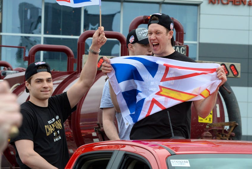 Growlers players Kristians Rubins (left) and Eric Levine (right), and trainer Patrick Quigley (rear) revel in the team’s motorcade through downtown St. John’s Friday evening.