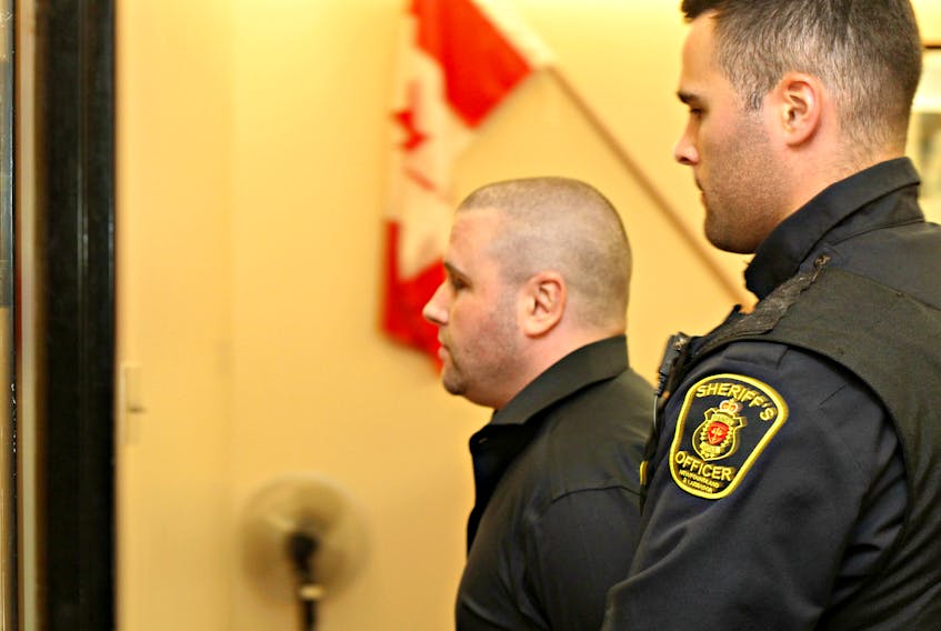 Dominic Delisle is escorted from the courtroom during a break in his sentencing hearing in St. John’s Wednesday afternoon. Delisle, 31, has admitted to renting a furnished condo under a fake name and stealing almost all its contents, shipping them to Quebec City.