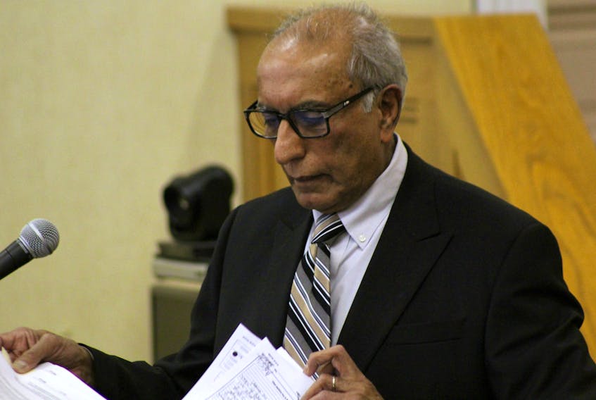 Forensic psychiatrist Dr. Nizar Ladha reviews his notes before continuing his testimony in the murder trial of Anne Norris after a lunch break Monday.