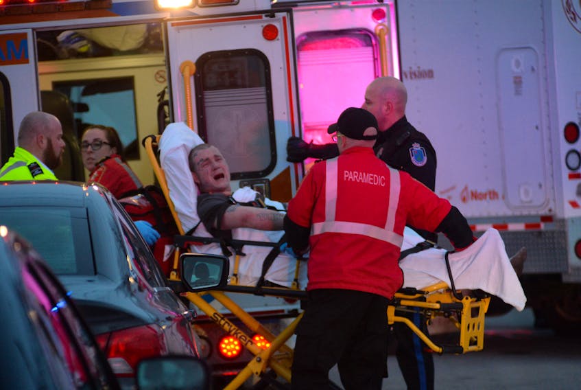 Justin Wiseman is wheeled to a waiting ambulance by Eastern Health paramedics after he was taken into custody by the RNC following a six-hour standoff at a house on Jersey Avenue in Mount Pearl on Tuesday.