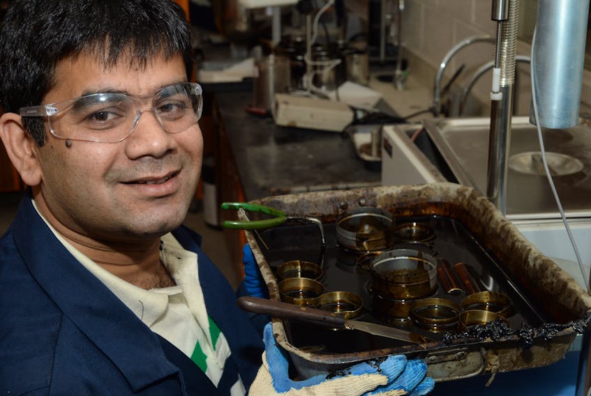 Kamal Hossain, an assistant professor of civil engineering at Memorial University, displays a pan of samples of oil that are used to make asphalt, in his MUN lab on Thursday morning.