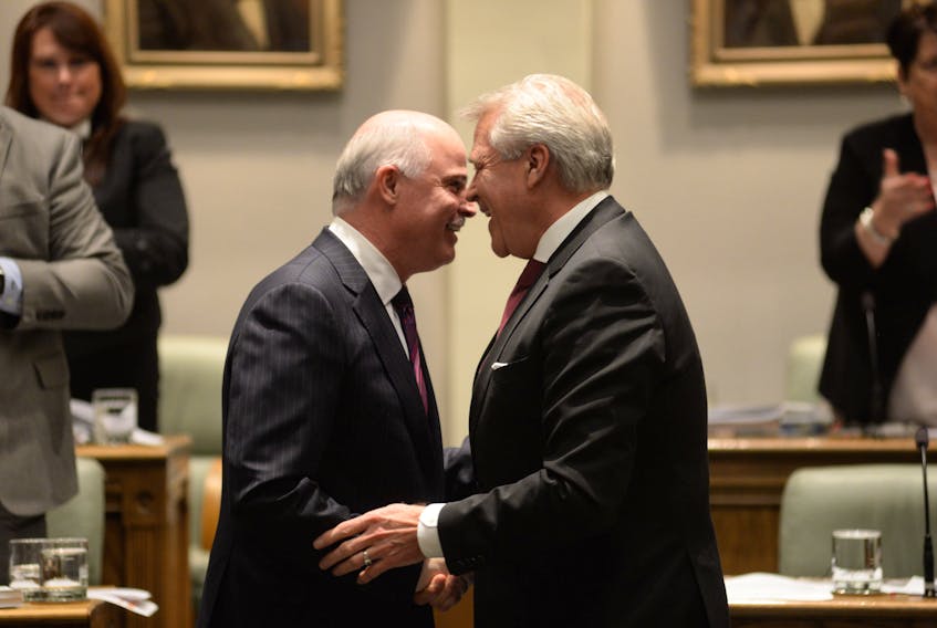 Finance Minister Tom Osborne (left) and Premier Dwight Ball greet each other in the House of Assembly on Tuesday, budget day.