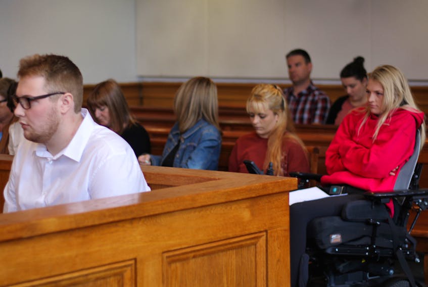 Joshua Steele-Young sits in the prisoner’s box at Newfoundland and Labrador Supreme Court in St. John’s Monday afternoon, as Morgan Pardy (right) sits behind him with her supporters.