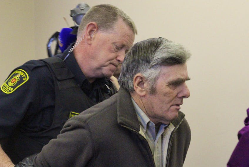 Chris Snow (right) is taken into custody by a sheriff's officer at Newfoundland Supreme Court in St. John’s Monday afternoon. Snow was convicted of 12 charges relating to the repeated sexual abuse of five children — boys and girls — in the 1960s and 1970s.