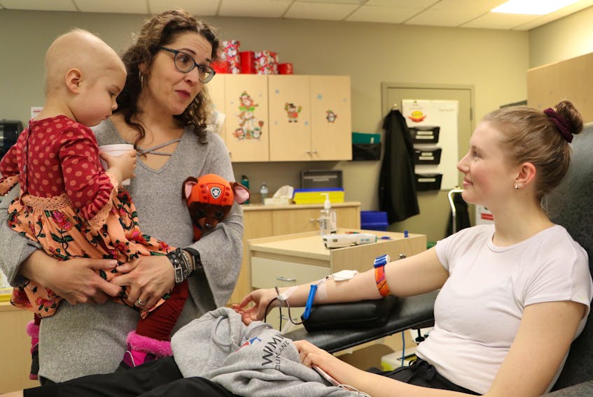 Veronica Vardy — holding her three-year-old daughter, Amelia, who was diagnosed with leukemia in July and has had a number of blood transfusions during her treatment — speaks with Holy Heart of Mary High School student Isabel Martin, who was donating blood at Canadian Blood Services in St. John’s Thursday. Vardy said she came to say thank you to blood donors and to introduce them to Amelia to put a face to someone whom blood donations has helped.