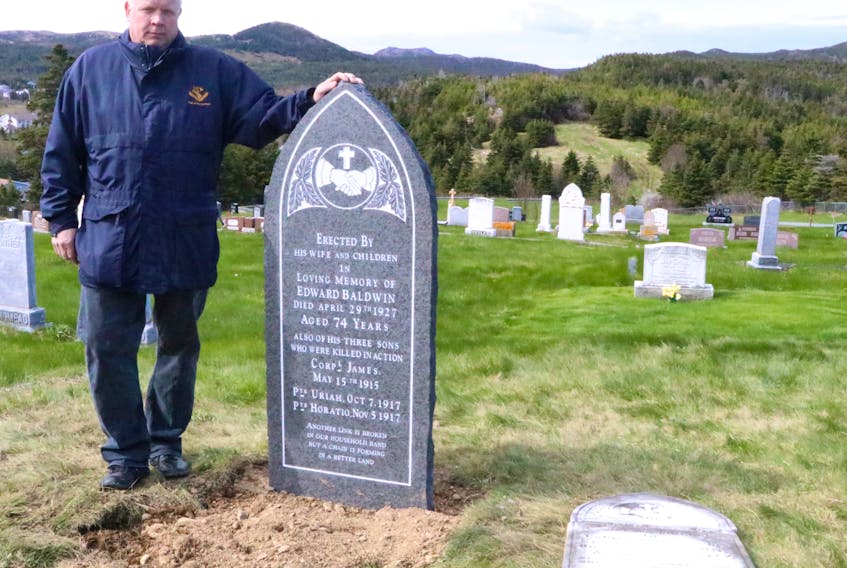 Maj. (Ret.) Michael Pretty of the Trail of the Caribou Research Group stands by a new grave marker at the All Saints Anglican Cemetery in Pouch Cove Friday. The marker replaces the fallen and broken headstone of Edward Baldwin, who had listed under his own name the names of his three sons killed during the First World War.