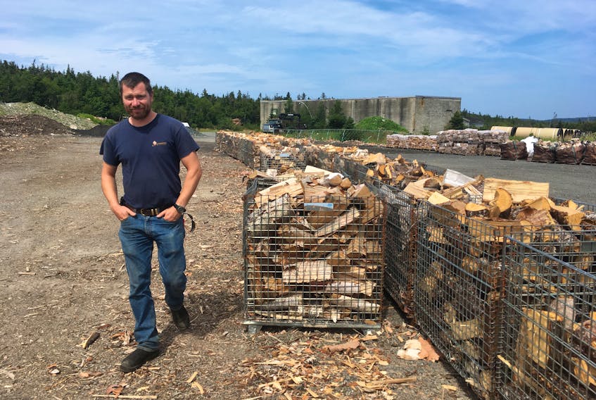 Luke Janes walks past bins of wood on a section of the Firewood Factory lot off Torbay Road in St. John’s Thursday. Janes said new customers are mentioning a switch to wood based on concern over increases in electricity rates.