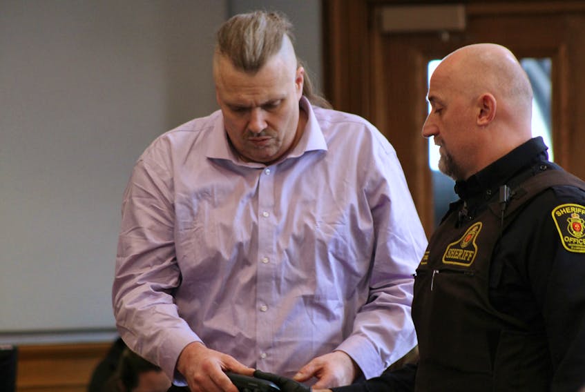 A sheriff's officer hands Allan Potter his reading glasses before the jury selection process begins for Potter's murder trial in Newfoundland and Labrador Supreme Court in St. John's Monday afternoon.