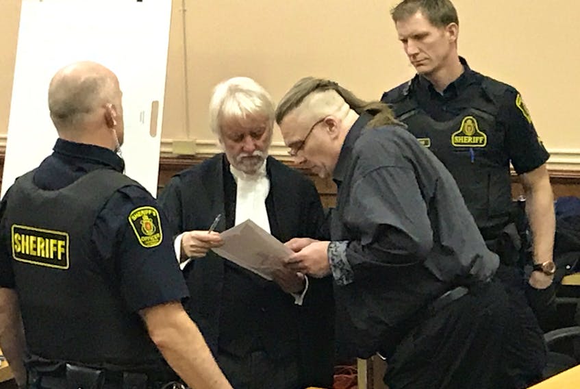 Allan Potter (right) consults with his lawyer, Randy Piercey, about evidence in his murder trial during a break in testimony Wednesday, as sheriffs wait to escort him back to the lockup.