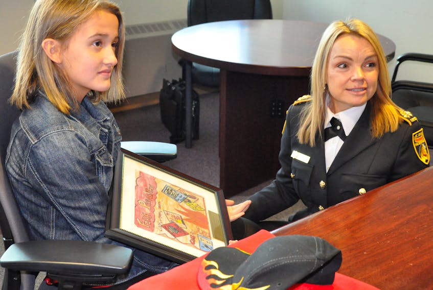 St. John’s Regional Fire Department (SJRFD) Chief Sherry Colford talks to Tianna Dawe about the fire prevention poster that won her the department’s annual Fire Chief for a Day contest.