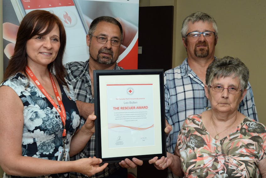 Presenting the award to Leo Bullen’s sons, Chris and Howard, and their mom, Hazel Bullen, is Gloria Warren Slade, philanthropy co-ordinator with the Red Cross in St. John’s.