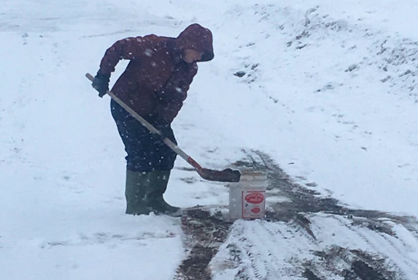 Daphne Bowers, 72, shovels sand onto the laneway leading to her home.