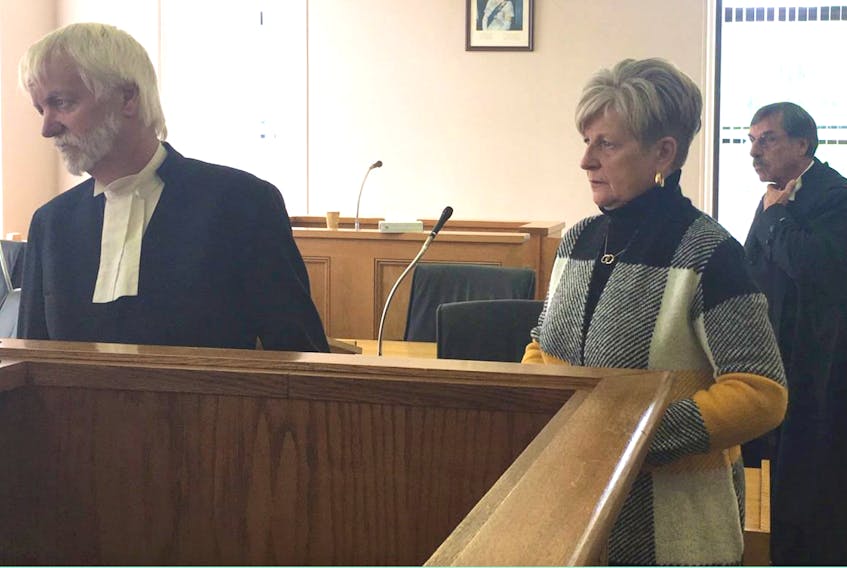 Former St. John's realtor Anne Squires waits for her lawyer, Randy Piercey (left) in the Supreme Court of Newfoundland and Labrador in St. John’s following Monday’s hearing. At right is Crown prosecutor Arnold Hussey. A sentencing hearing for Squires has been set for December on charges of theft, fraud and forgery.