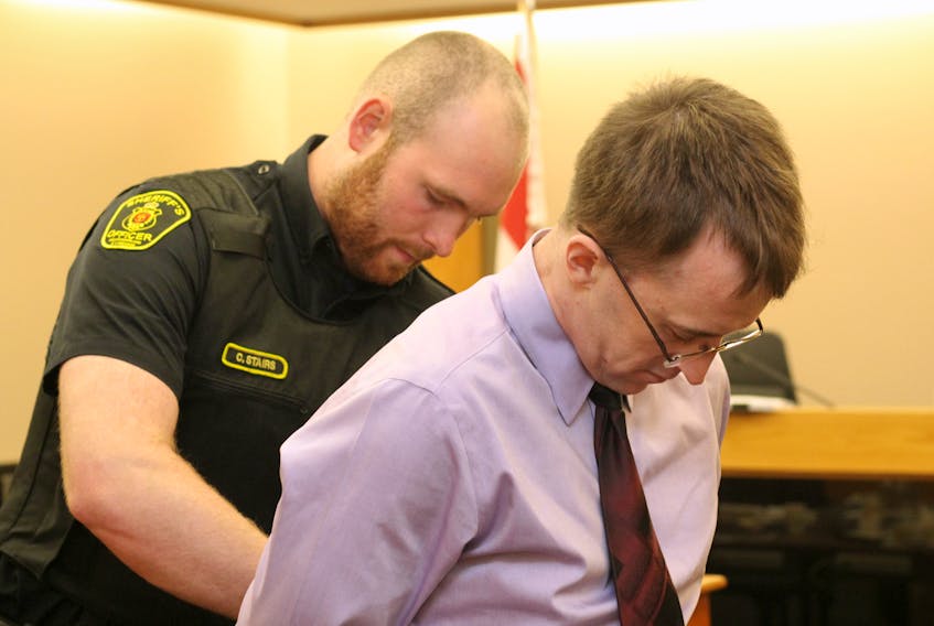 A sheriff's officer puts handcuffs on Thomas James Keeping, 32, before escorting him back to the lockup at provincial court in St. John’s Thursday morning, during a break in Keeping’s trial. He is facing a number of charges in connection with an alleged stabbing on Outerbridge Road in the west end of St. John's last November.