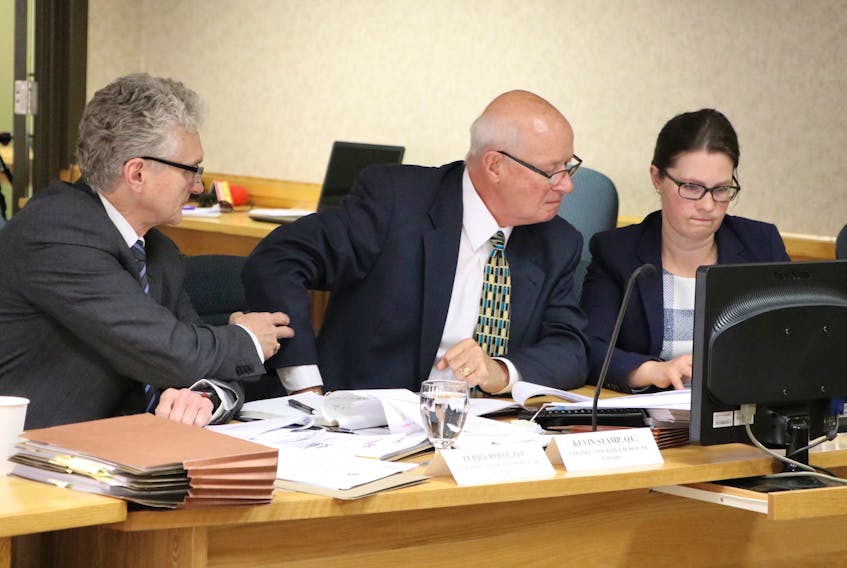 From left, lawyers Terry Rowe and Kevin Stamp confer with Amanda Dean, vice-president Atlantic of the Insurance Bureau of Canada, during a break in hearings at the Public Utilities Board this week.