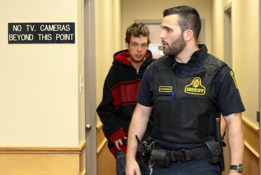 Jake Conway, 22, is escorted out of a St. John's courtroom late Tuesday afternoon, after he was released from custody on bail. Conway is facing up to 10 years in prison for allegedly sexually assaulting a woman on Sunday.