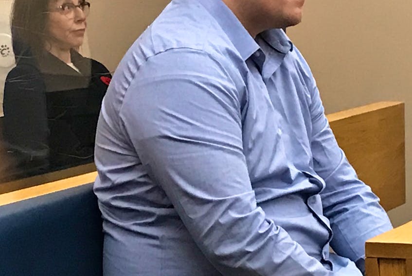 Brandon Phillips, 30, awaits the start of his sentencing hearing on drug possession charges in provincial court in St. John's Tuesday. Behind him is Linda McBay, the spouse of Larry Wellman, whom Phillips was convicted of murdering in the second degree. McBay has vowed to attend all Phillips' court appearances and parole board hearings.