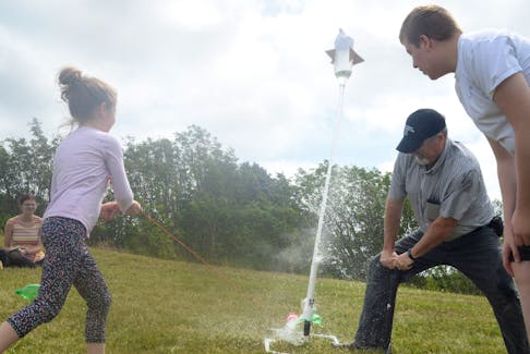 One of the summer camp participants launches their team’s bottle rocket with the assistance of former schoolteacher John Barron, now program co-ordinator for Brilliant Labs, Wednesday on the large green-space embankment on the west end of the College of the North Atlantic campus on Prince Philip Drive.
