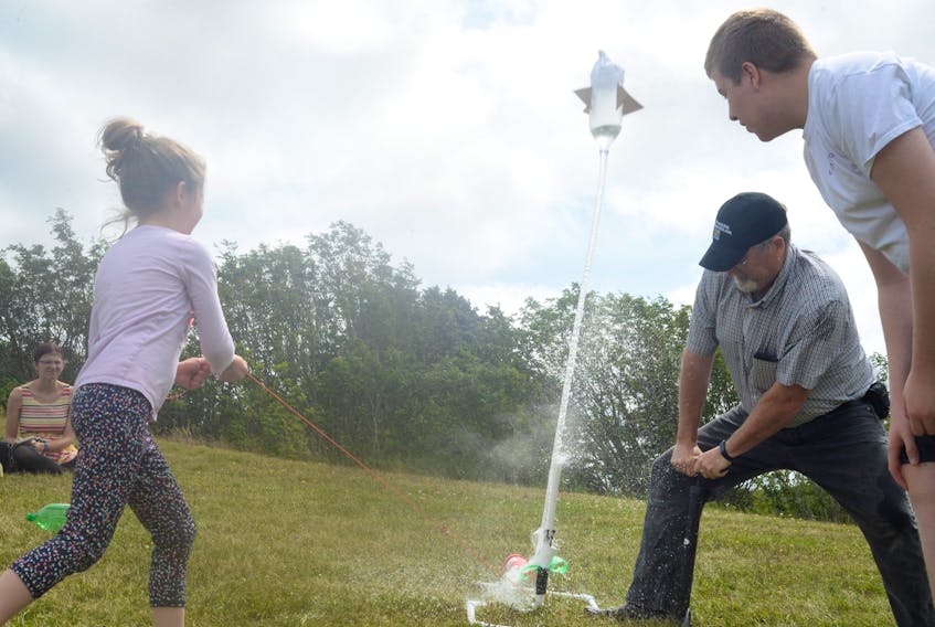 One of the summer camp participants launches their team’s bottle rocket with the assistance of former schoolteacher John Barron, now program co-ordinator for Brilliant Labs, Wednesday on the large green-space embankment on the west end of the College of the North Atlantic campus on Prince Philip Drive.