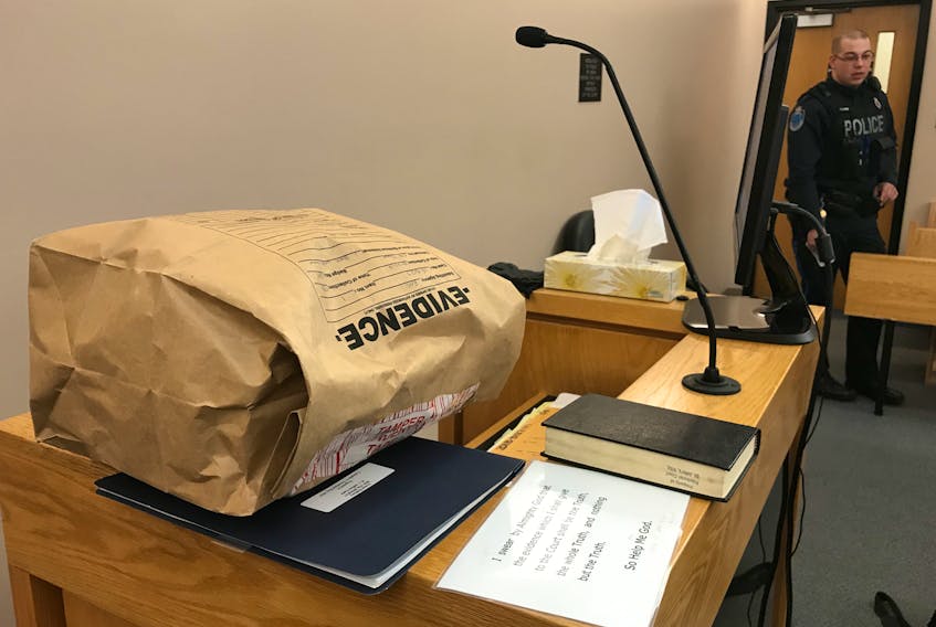 An RNC evidence bag sits on the witness stand in provincial court in St. John’s Wednesday. Inside is a jacket seized from armed robbery suspect Jeffrey Earle last July. RNC Const. Terence Reid, who testified at Earle’s trial Wednesday afternoon, is in the background.