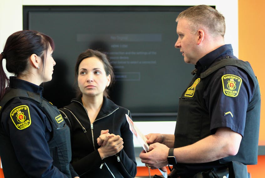 Rose Ricciardelli (centre), co-author of a paper commissioned by the Newfoundland and Labrador Association of Public and Private Employees (NAPE) calling for new legislation for work-related stress injuries, speaks to two sheriff’s officers Tuesday morning, after a news conference to present the paper.