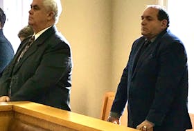 Gary Hillyard (left) and John King stand as Newfoundland and Labrador Supreme Court Justice Deborah Paquette enters the courtroom in St. John's Thursday morning.