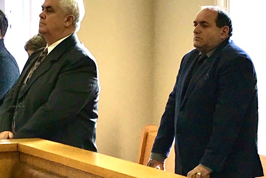 Gary Hillyard (left) and John King stand as Newfoundland and Labrador Supreme Court Justice Deborah Paquette enters the courtroom in St. John's Thursday morning.