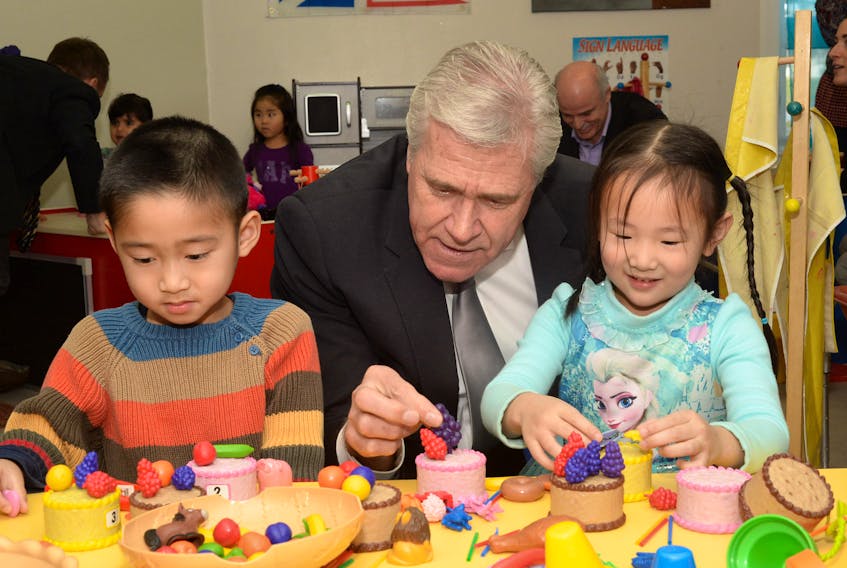 Premier Dwight Ball does some toy cake decorating with Bao (Moon) Nguyen, 4, and Jacqueline Li, 4, Friday at Campus Childcare.