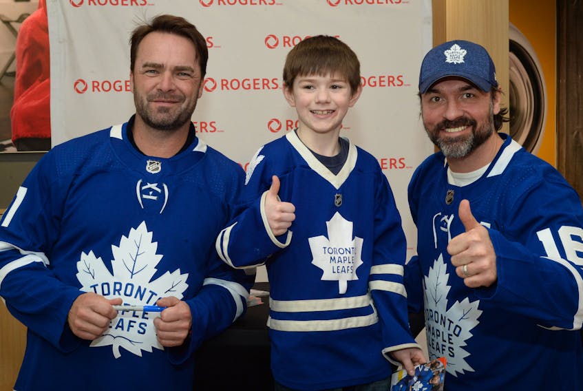 Tristan Jenkins, 8, a student at Carbonear Academy, poses with former Toronto Maple Leafs players Curtis (CuJo) Joseph (left) and Darcy Tucker after getting autographs on his Leafs memorabilia.