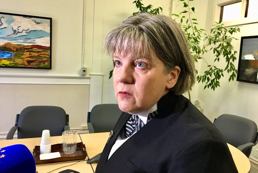 Lawyer Lynn Moore speaks to reporters at Newfoundland Supreme Court in St. John's Tuesday about what she says are too many delays by the government to provide information about one of her clients, who reportedly suffered abuse while in foster care years ago.