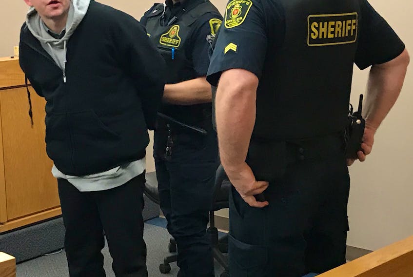 Sheriff's officers handcuff Ryan Farrell and prepare to escort him from a St. John's courtroom, where he was convicted Thursday of assaulting and threatening a woman.