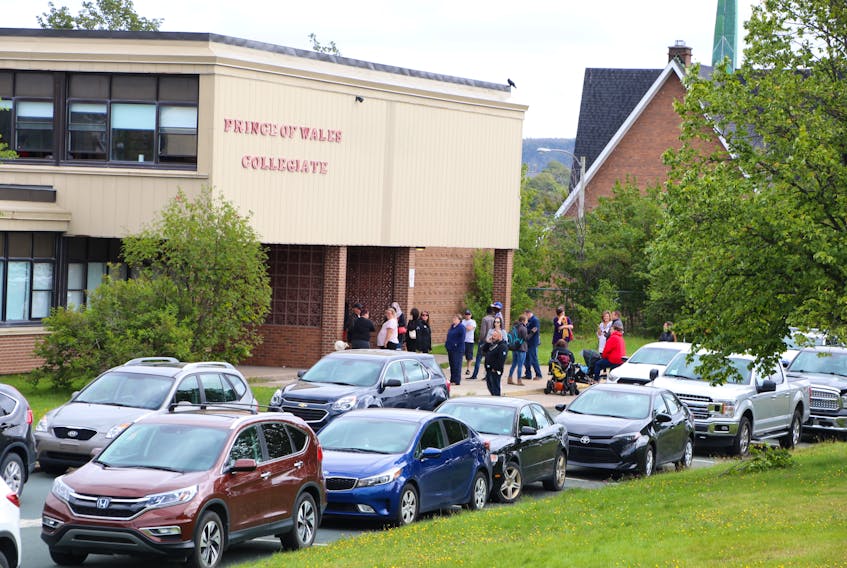 Parents wait outside Prince of Wales Collegiate in St. John’s Wednesday to pick up their children. The school went into secure mode after an incident in which several students were hit with bear spray.