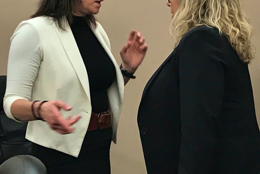 Debbie McGrath (right) speaks with her lawyer, Rosellen Sullivan, during a break in her trial in provincial court in St. John's Monday.