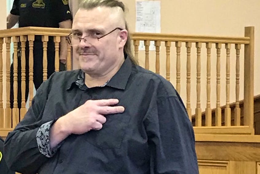 Allan Potter, 55, makes a Vikings Motorcycle Club salute as he awaits the judge at the start of his murder trial in St. John’s Friday morning. Potter is expected to testify on Tuesday.