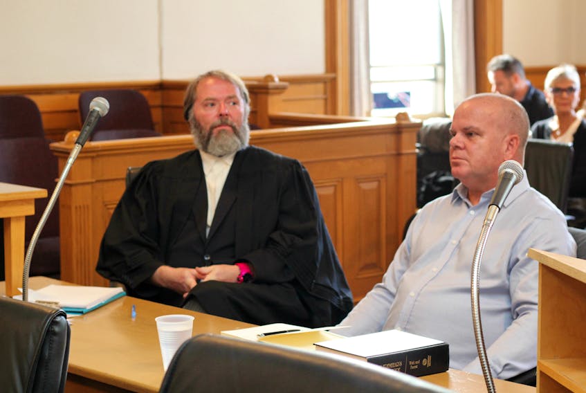 Mark Rumboldt (right) sits with his lawyer, Jeff Brace, waiting for court proceedings to start after a break Tuesday morning.