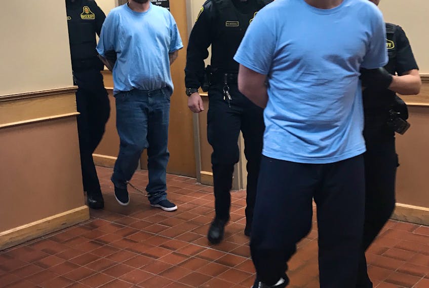 Adam Hayden (front) and Travis Wade (rear) are escorted out of provincial court in St. John’s Monday after making their second appearance before a judge on charges related to an armed robbery at TD bank Friday evening. Hayden is also facing charges in connection with the attempted carjacking of a vehicle, as well as shoplifting.